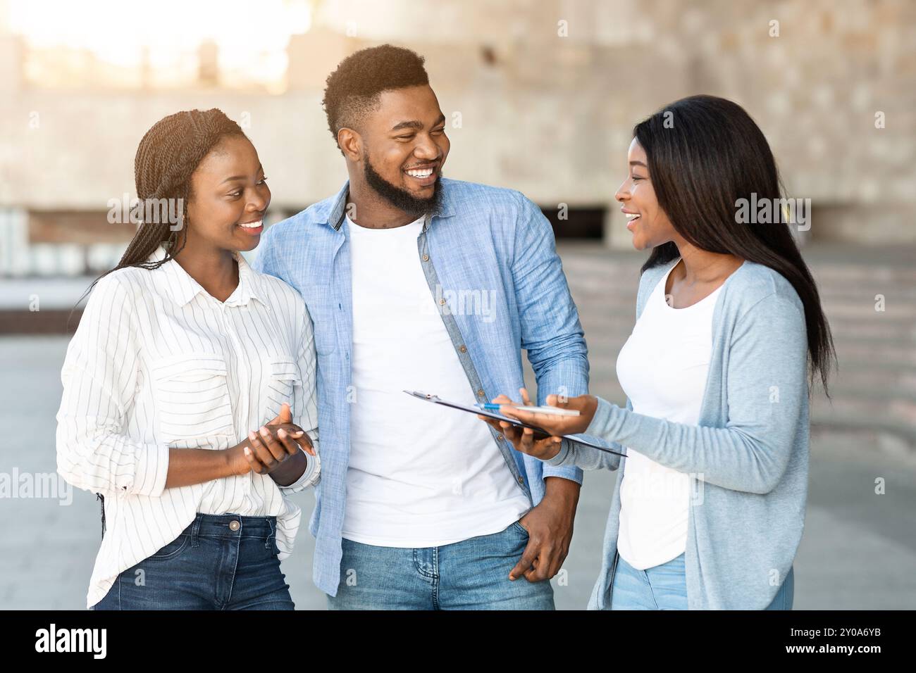 Woman with clipboard asking social survey with young couple Stock Photo