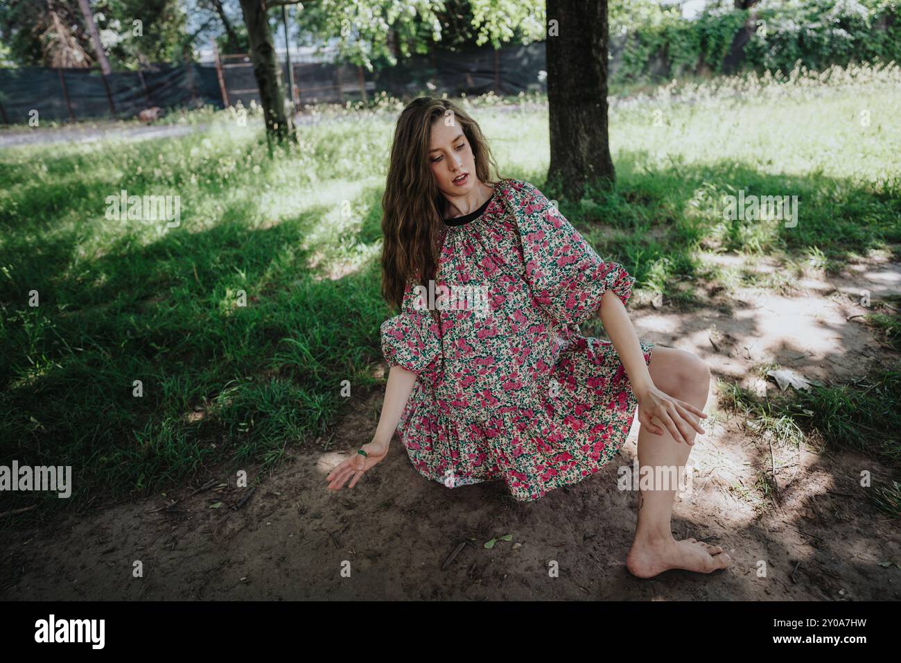 Girl performing expressive modern dance in nature wearing floral dress Stock Photo
