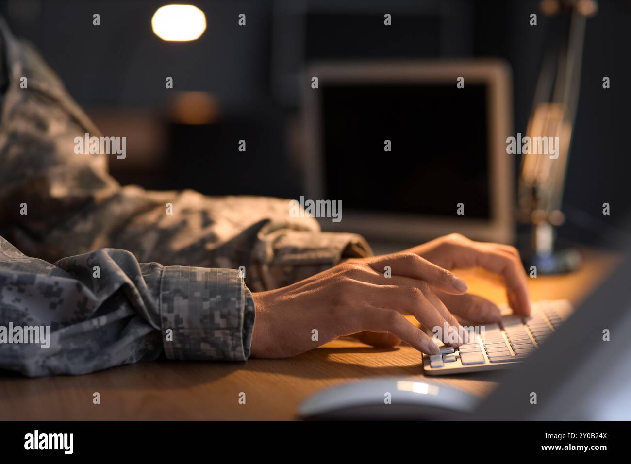 Female soldier working with computer in headquarters at night, closeup ...