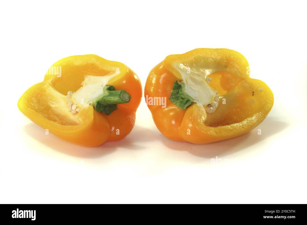 Two yellow pepper halves on a white background Stock Photo - Alamy