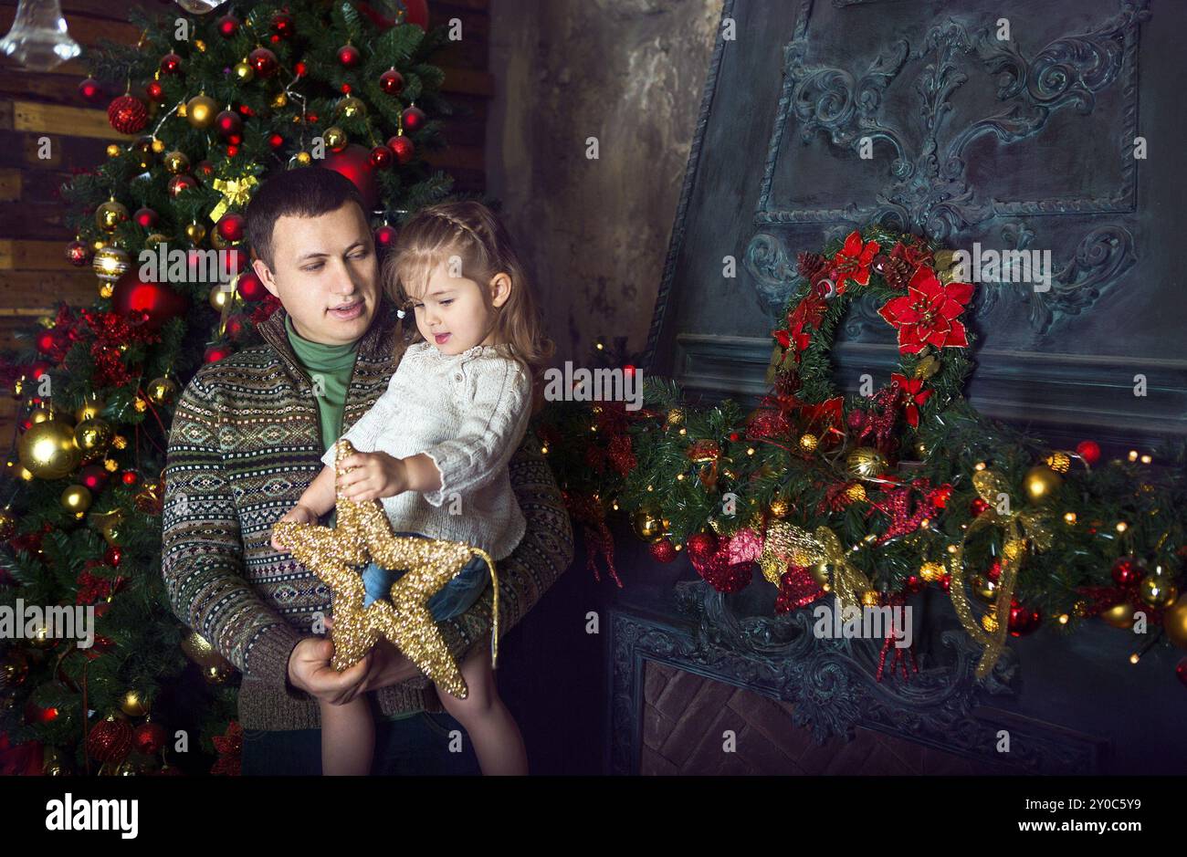 Happy father and his little daughter decorating the Christmas tree at ...