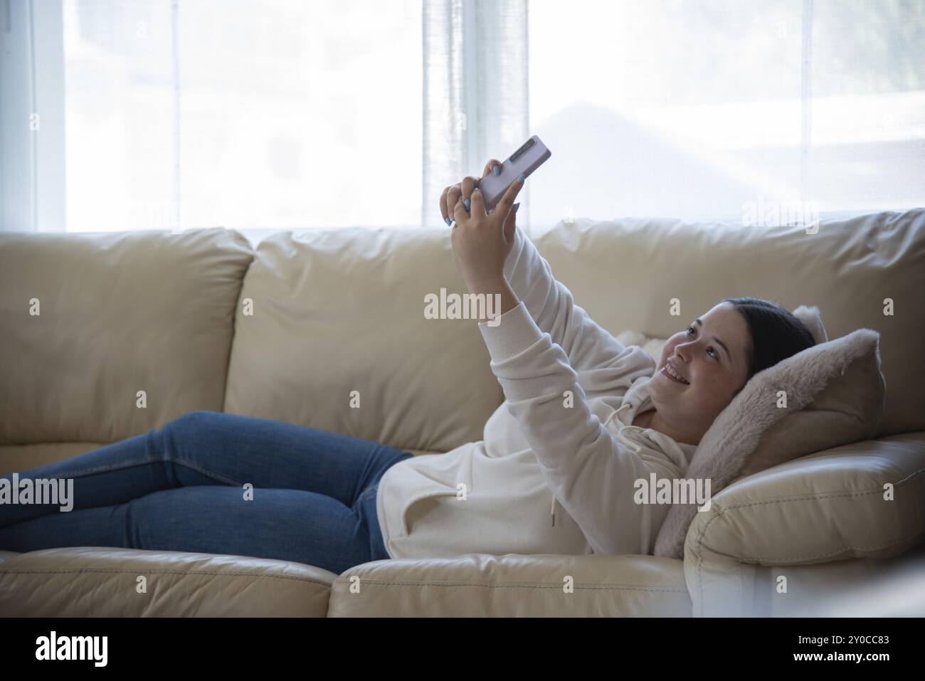 Girl lying comfortably on sofa hi-res stock photography and images - Alamy