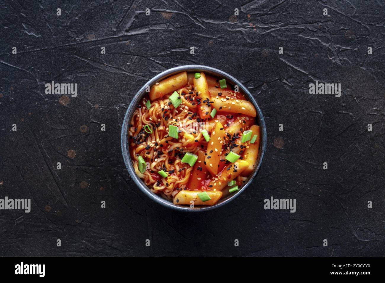 Rabokki, tteokbokki or topokki with ramen, Korean street food, spicy rice cakes in red pepper gochujang sauce, overhead flat lay shot, Food photograph Stock Photo