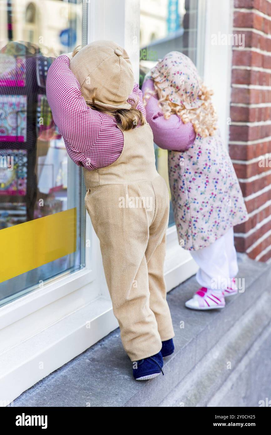 Puppets boy and girl look through shop window Stock Photo