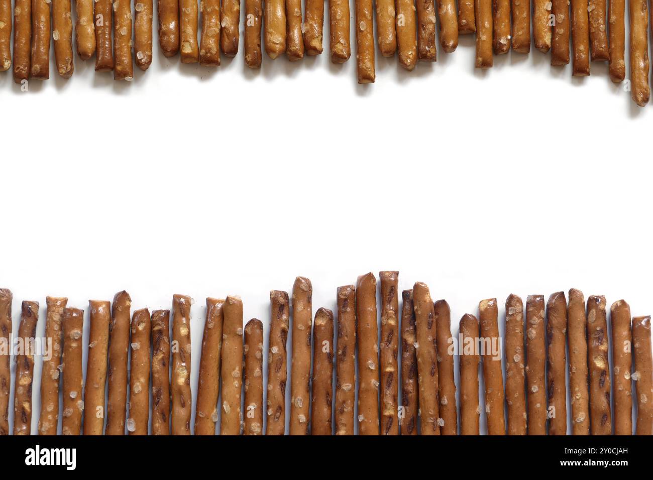 Salted pretzel sticks in two rows on a white background Stock Photo
