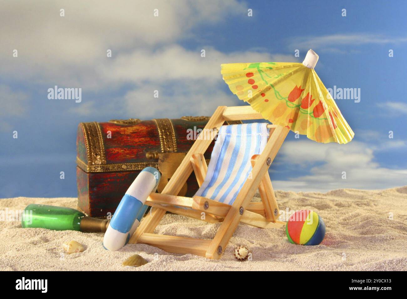 Old treasure chest with message in a bottle, deckchair and bathing ...