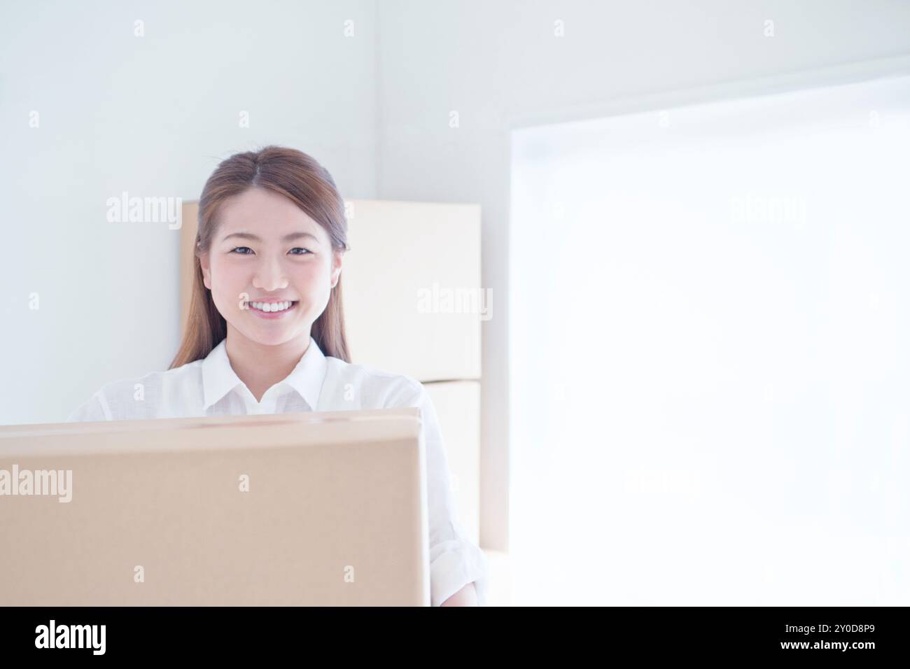 A woman with a cardboard box smiling Stock Photo - Alamy
