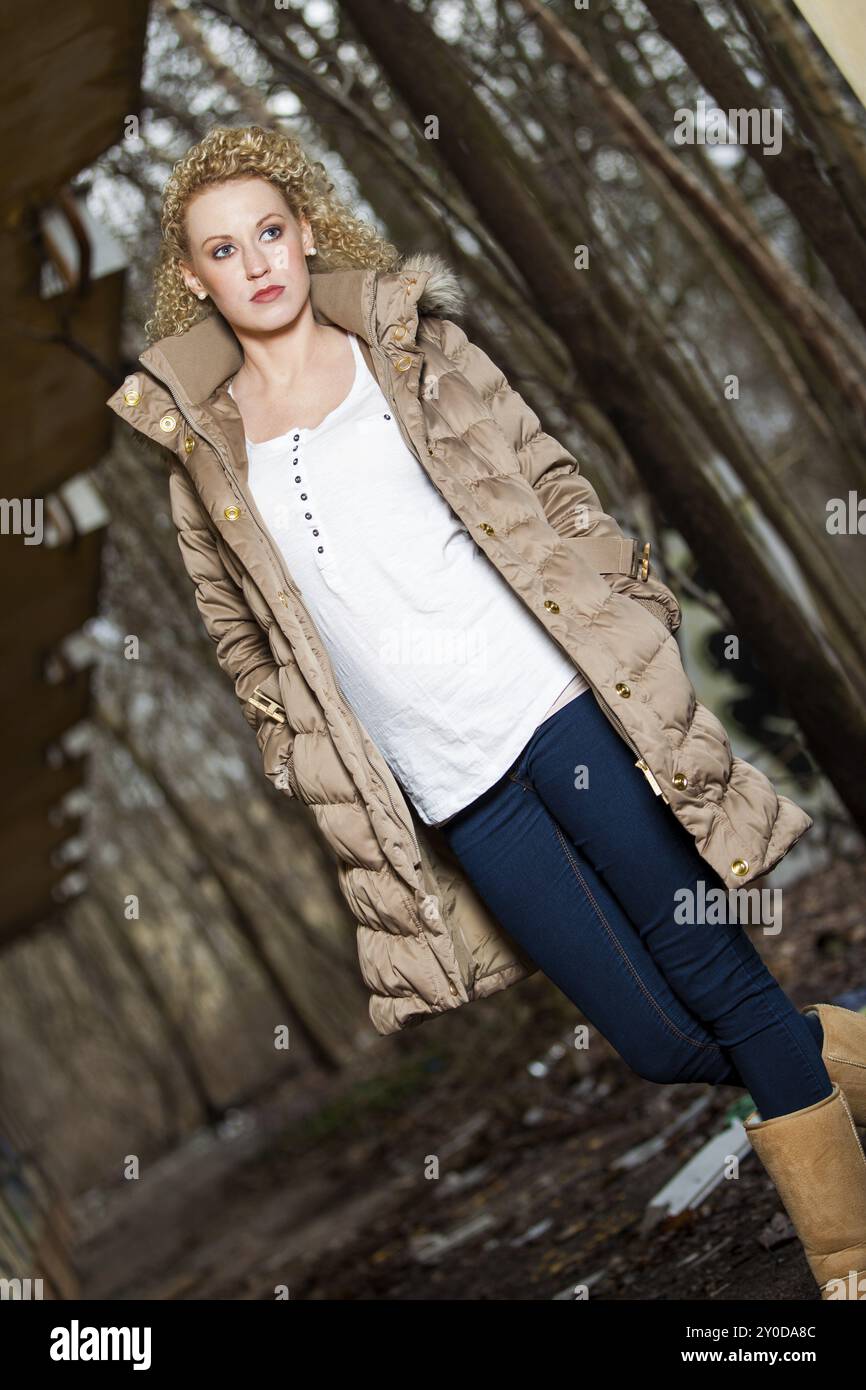 Young blonde woman with long curly hair in outdoor autumn environment Stock Photo