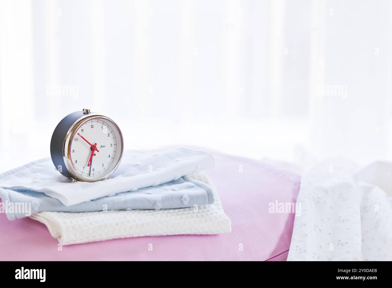 Alarm clock on the bed Stock Photo - Alamy