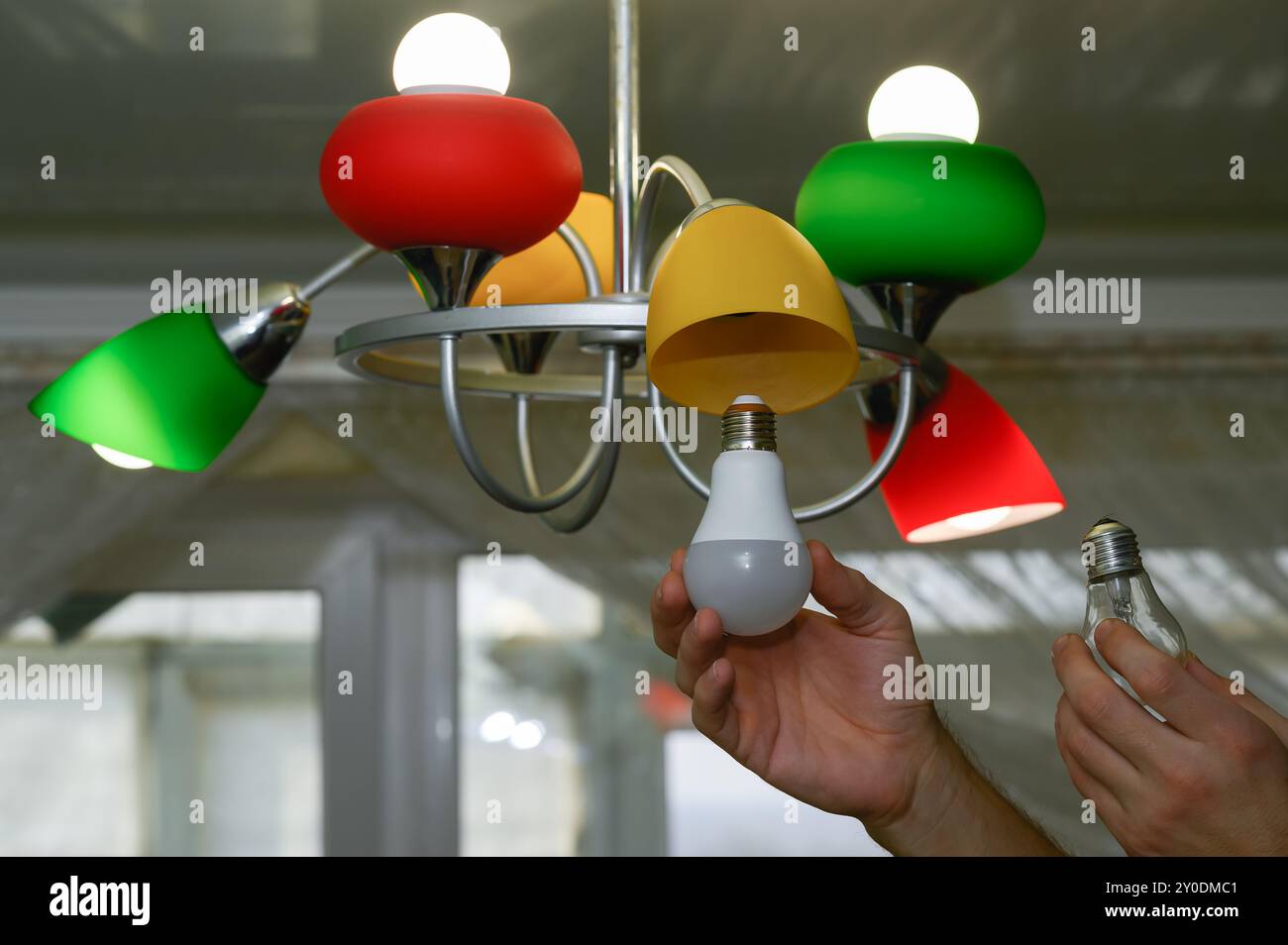 the concept of replacing an incandescent lamp with an LED one. Stock Photo