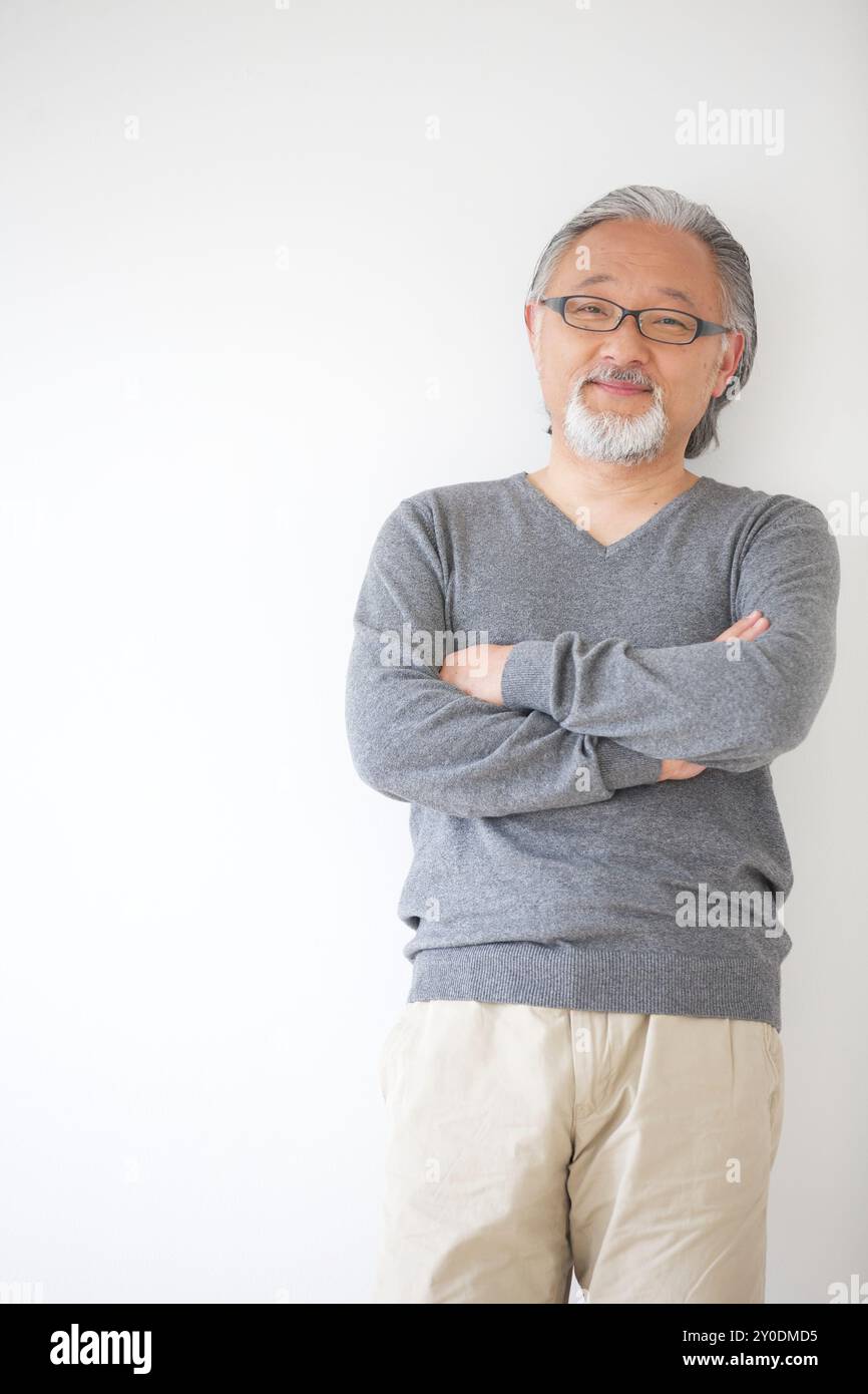 A senior man standing with his arms crossed Stock Photo - Alamy