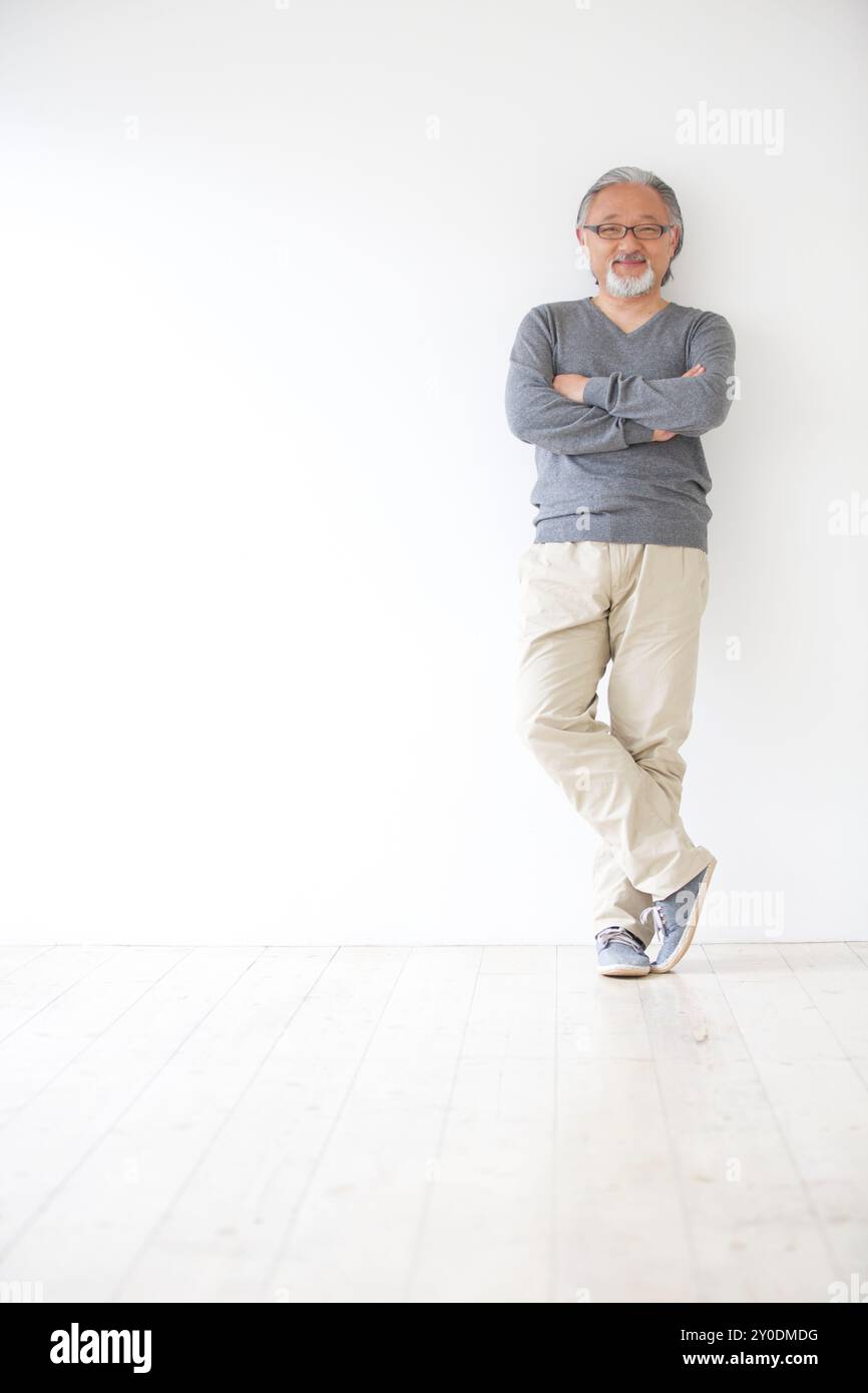 A senior man standing with his arms crossed Stock Photo - Alamy