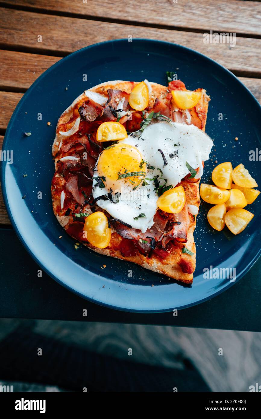 Homemade pinsa topped with savory ingredients, fresh tomatoes, a Stock Photo