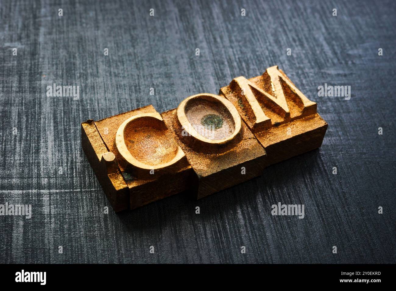 Close-up of typographic brass letters spelling com. Domain and online branding. Stock Photo