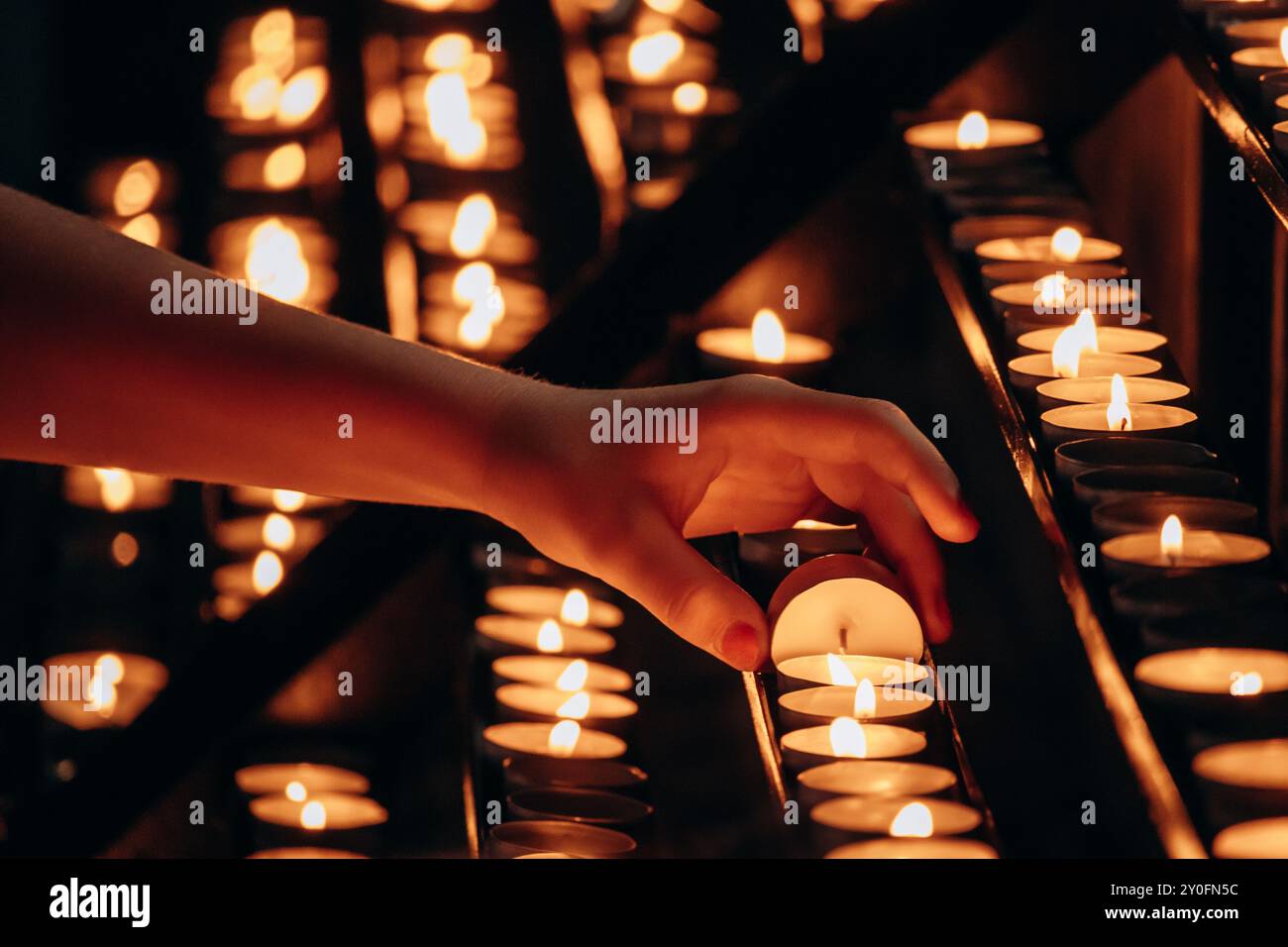 A woman's hand lighting a candle in a church Stock Photo - Alamy