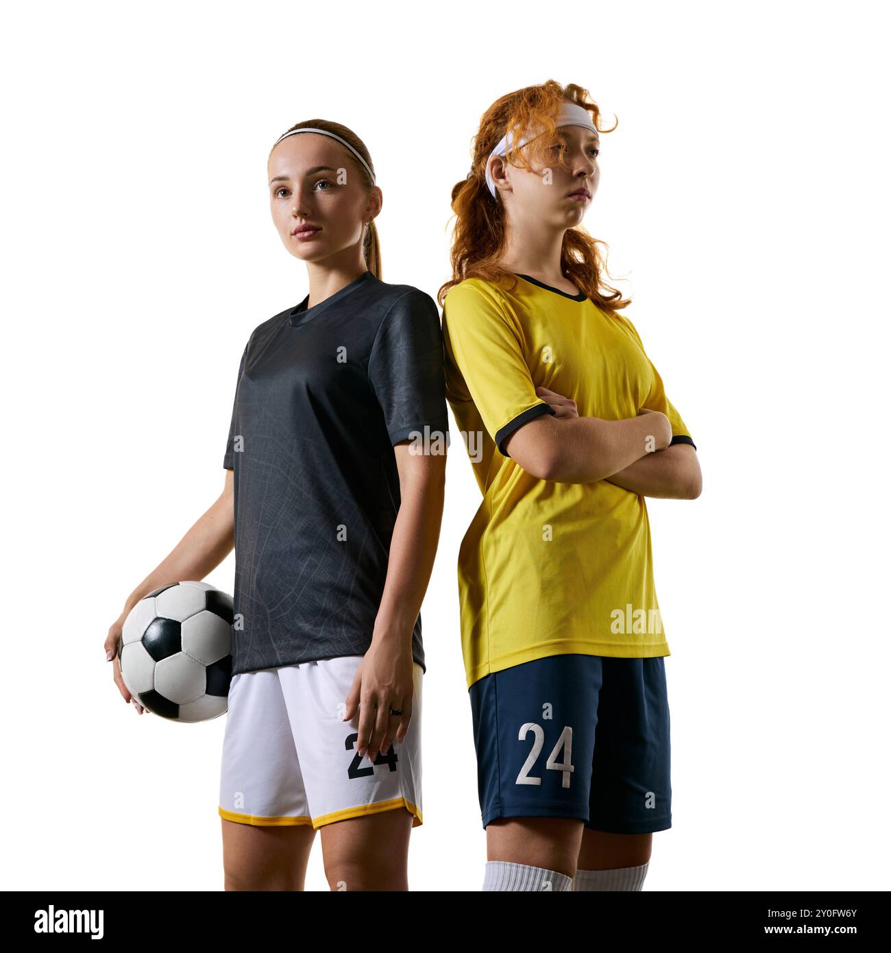 Athletic young women, soccer players, standing back-to-back on field ...