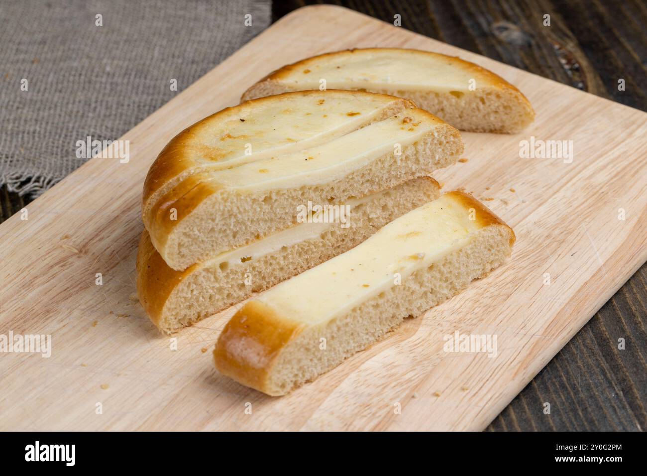 Cut into pieces round bun with creamy sour cream filling, sour cream bun for tea Stock Photo