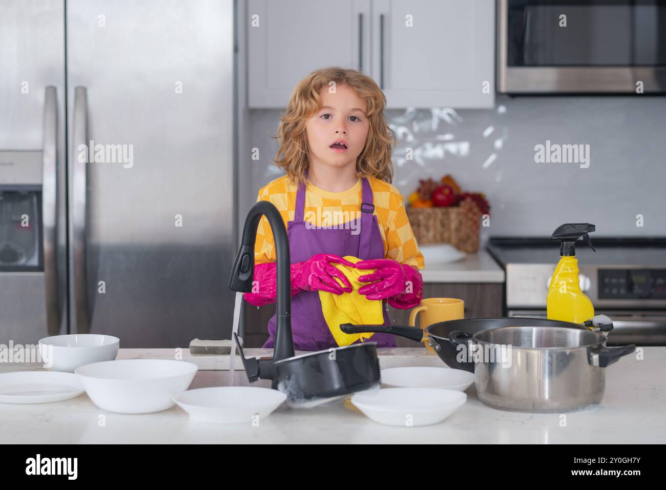Child Helping In Kitchen Child helping with household, wiping dishes in kitchen. Child helper ...