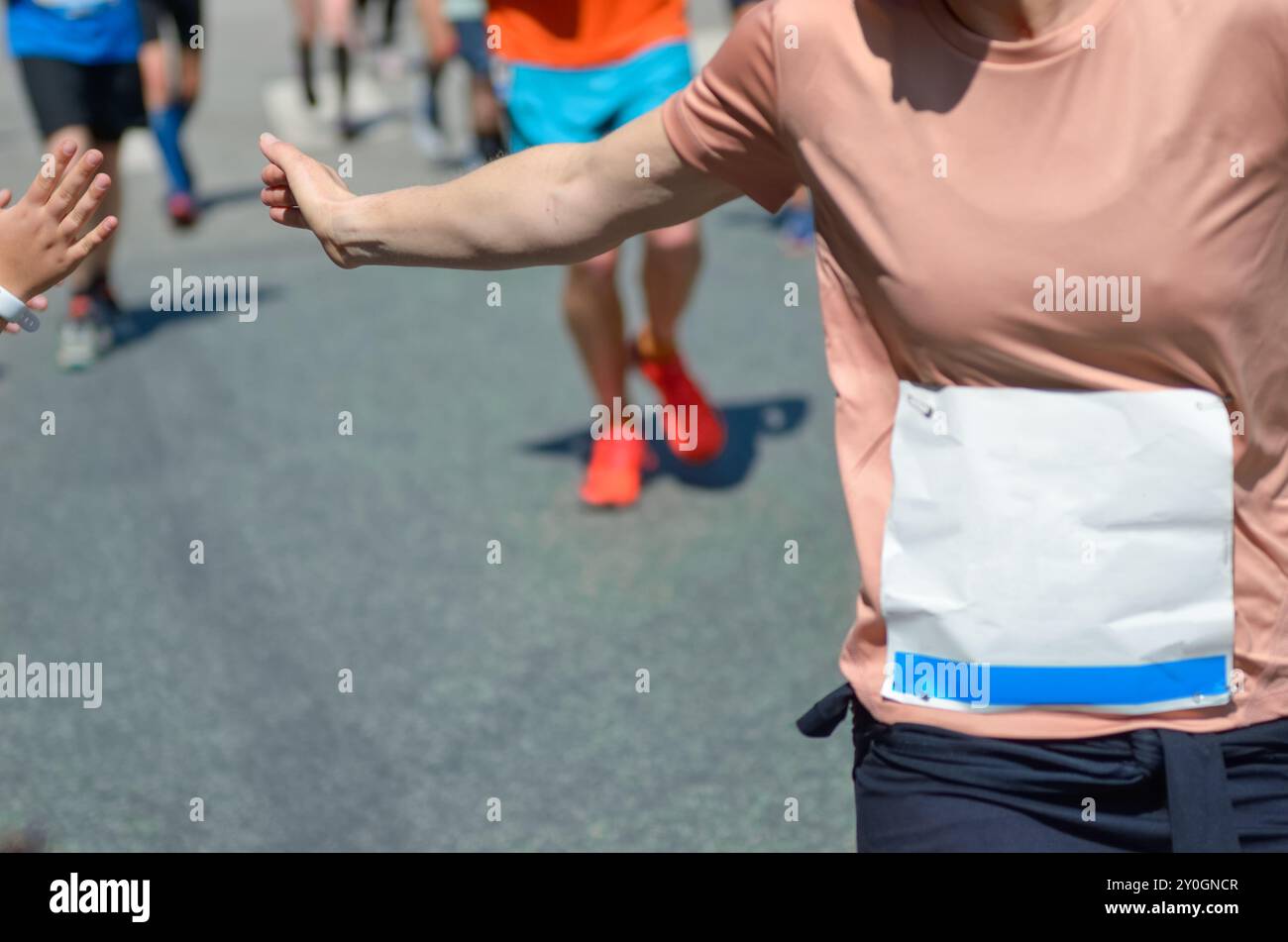 Marathon running race,runners support on road race, child's hand giving ...