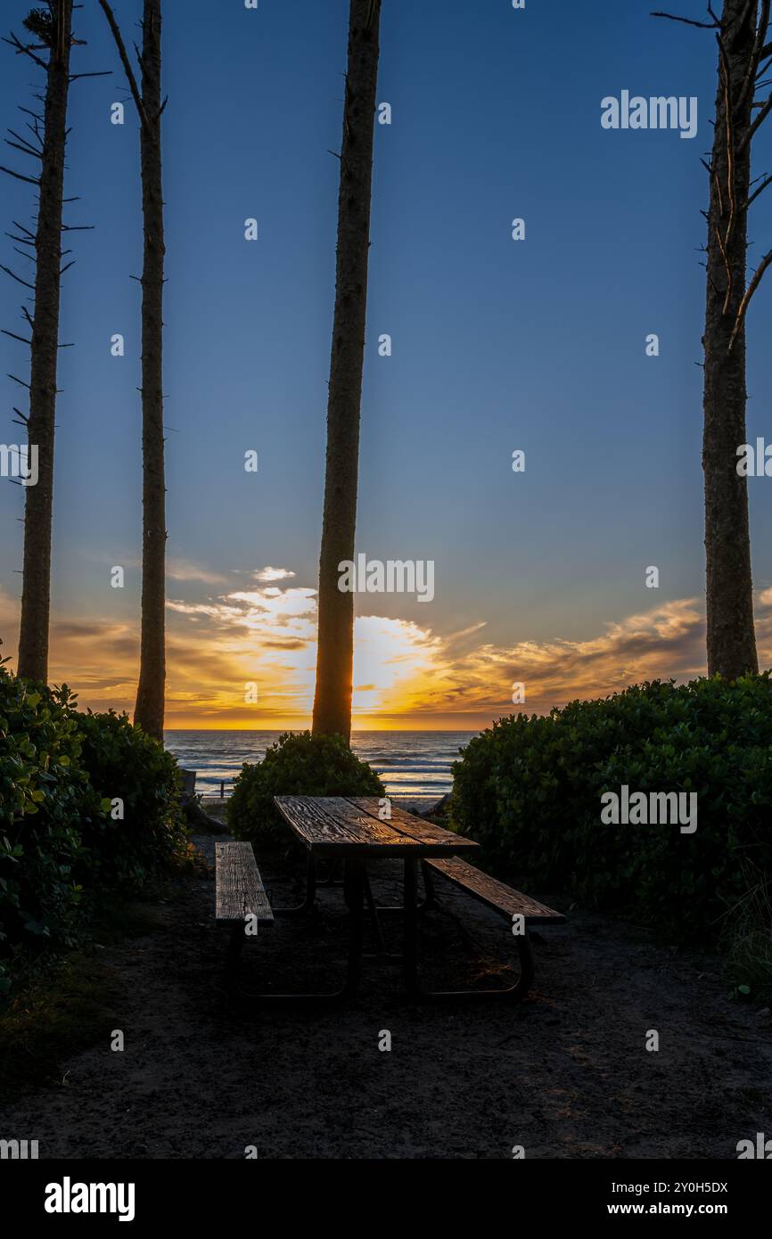 Pinick table lit up by sunset red and orange hues at Cape Lookout State Park day use area, Oregon USA Stock Photo