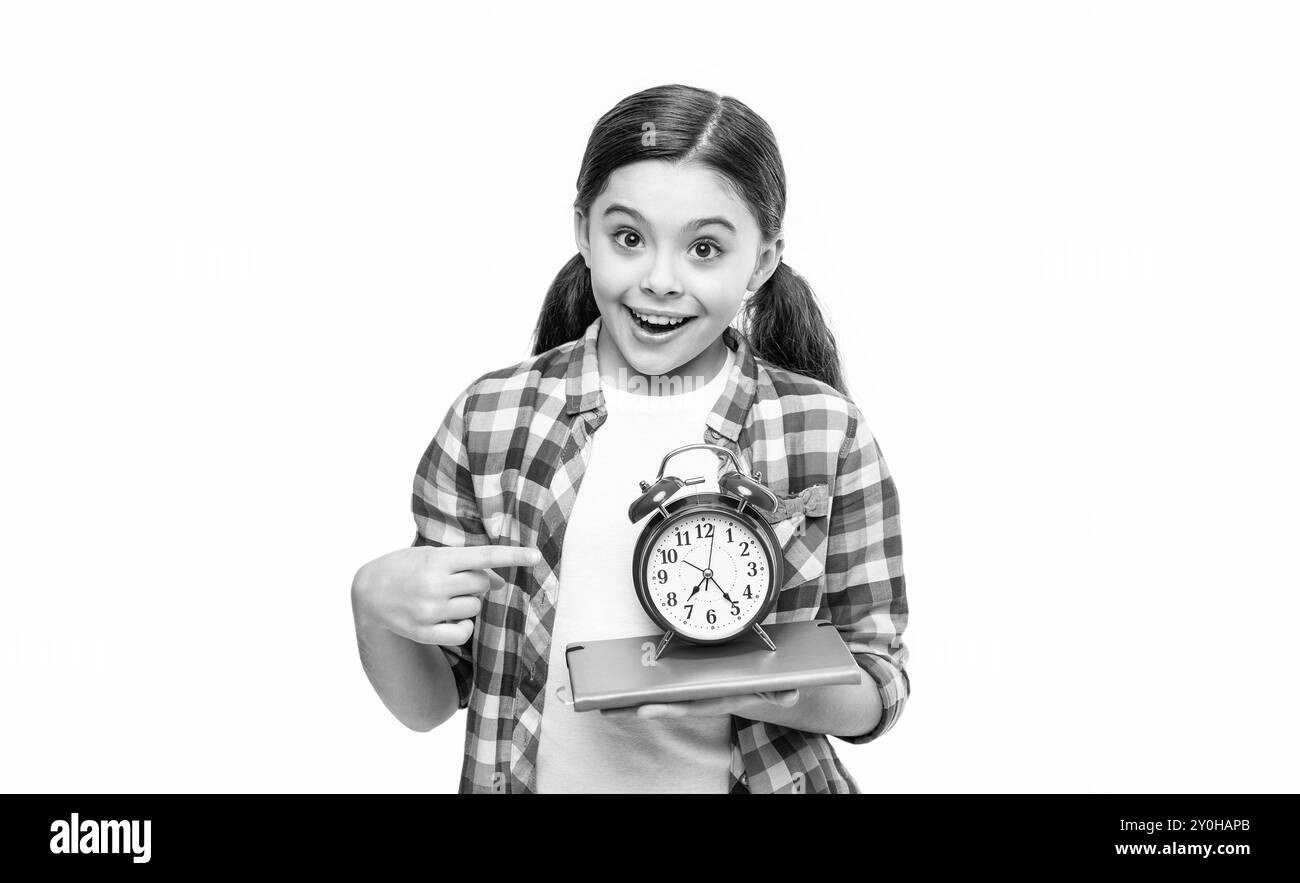 photo of amazed school girl with alarm clock and homework. school girl ...