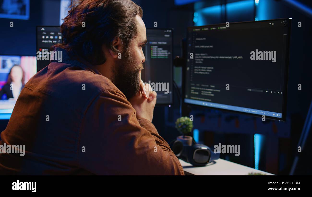 Cheerful software technician feeling satisfied after removing all bugs while coding on computer, close up. Smiling IT expert looking at screen, happy after solving script errors, camera B Stock Photo