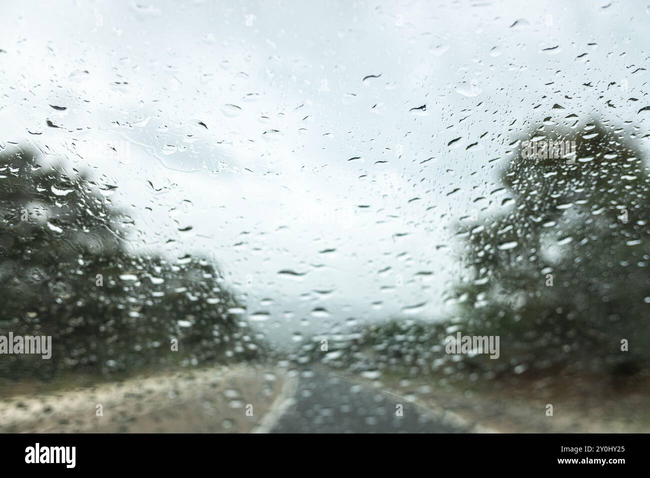 selective focus of raindrops on the windshield of a car in a fall storm ...