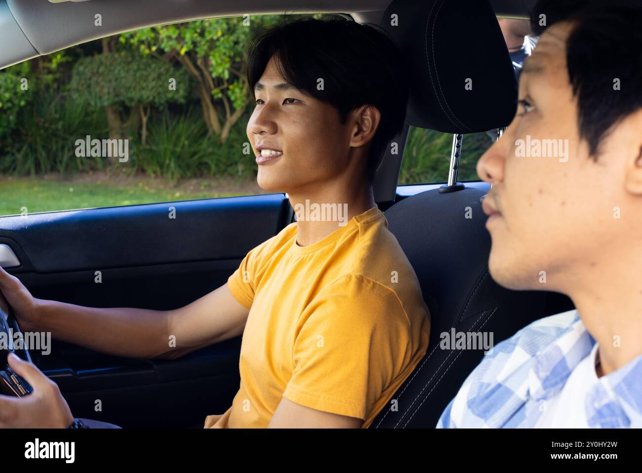 Driving car, young asian man learning with instructor, focusing on road ahead Stock Photo
