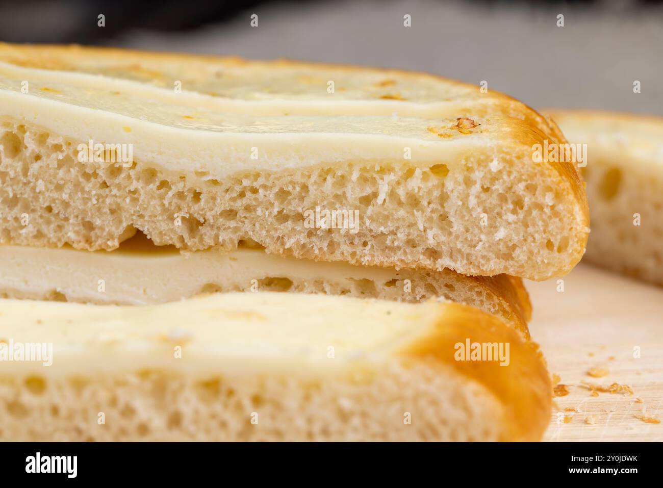 Cut into pieces round bun with creamy sour cream filling, sour cream bun for tea Stock Photo