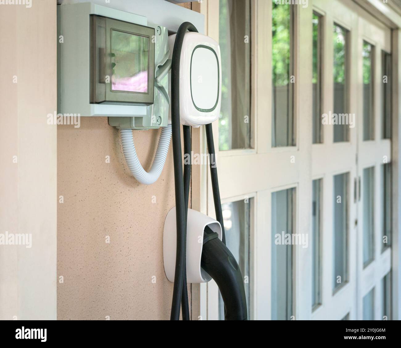 Wall charging station for electric car installed in a residential house. Stock Photo