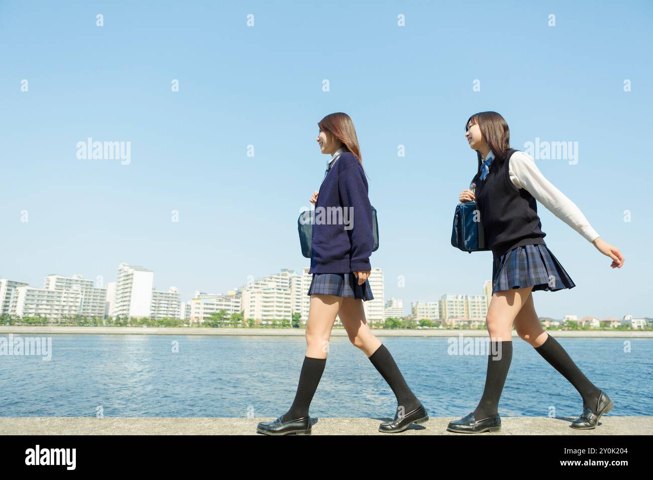 Japanese high school girl walking on a breakwater Stock Photo - Alamy