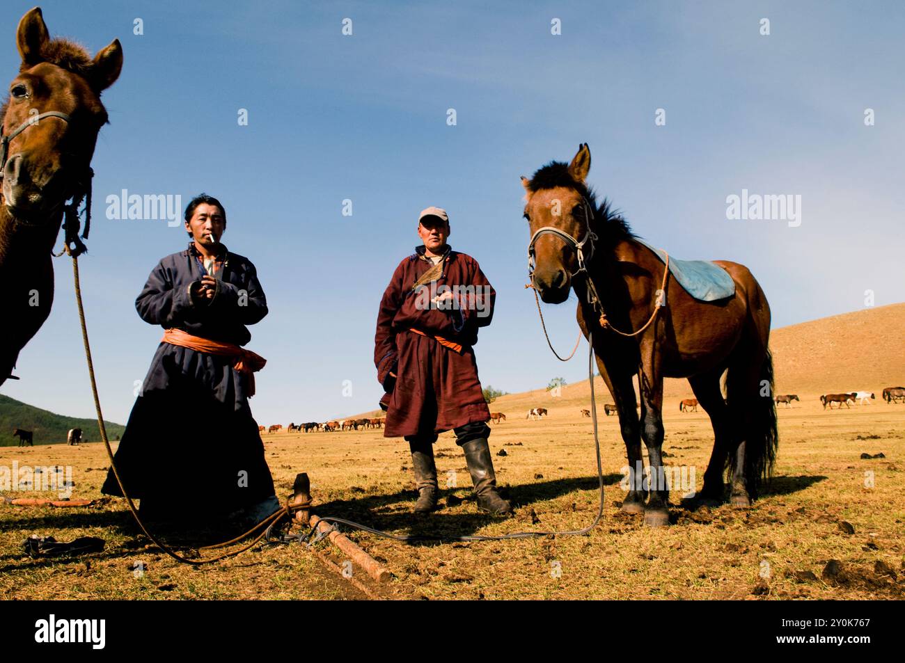 Mongolian nomads enjoy a cigarette break in the vast Mongolian ...