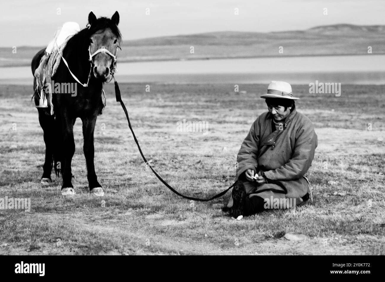 A Mongolian nomad rests by his horse near Ogii lake ( Nur ). Stock Photo