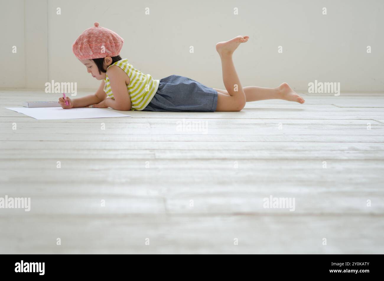 Girl lying on the floor while drawing pictures Stock Photo - Alamy
