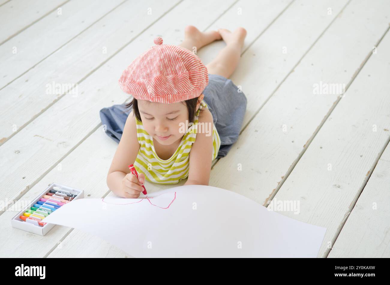 Girl lying on the floor while drawing pictures Stock Photo - Alamy