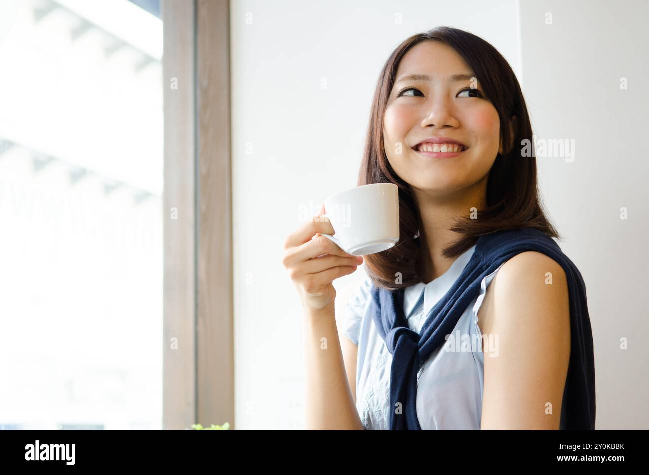 The woman smiling with a coffee cup Stock Photo - Alamy