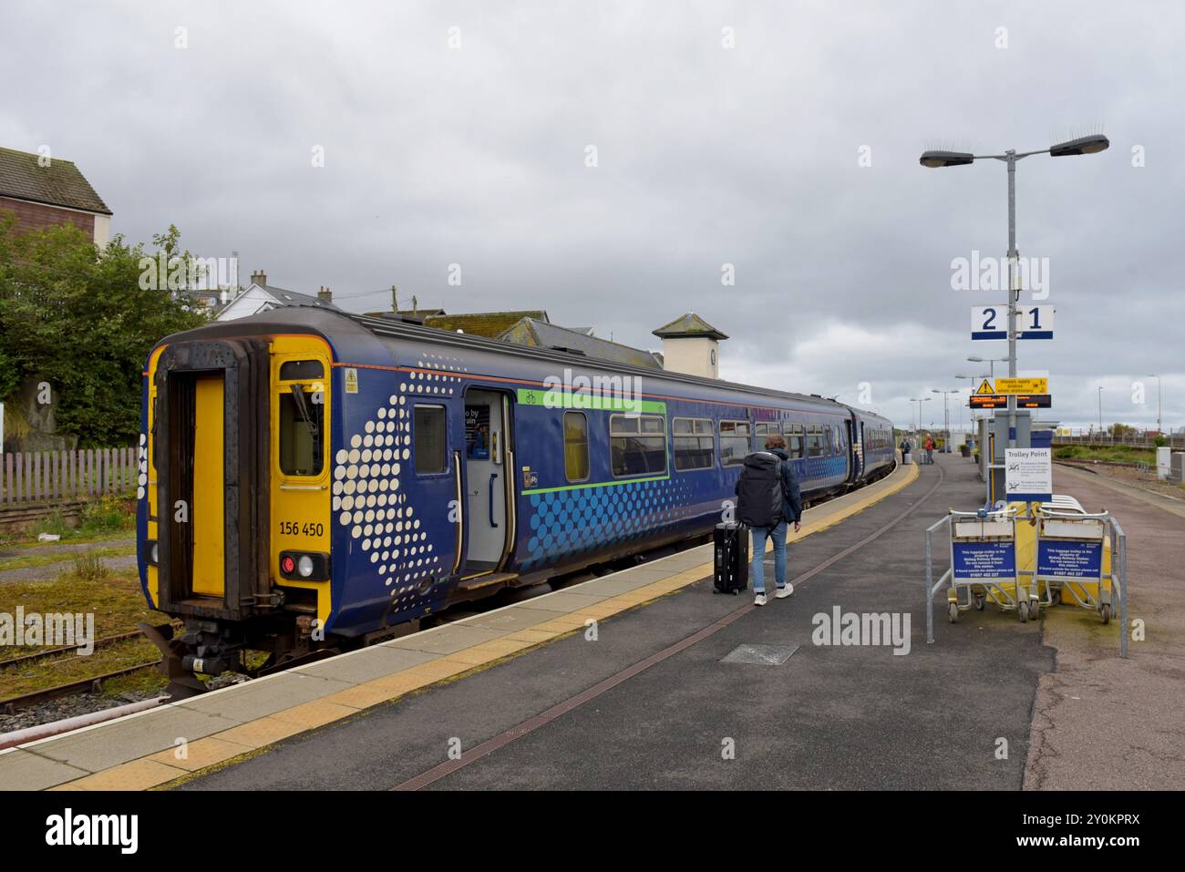 A passenger walking towards a Scotrail DMU Sprinter train at Mallaig Station , West Highland line, Scotland, July 2024 Stock Photo