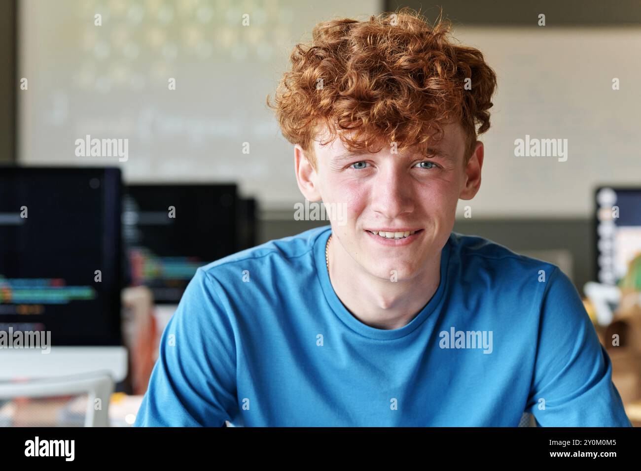 Smiling Student Sitting at Desk in School Stock Photo
