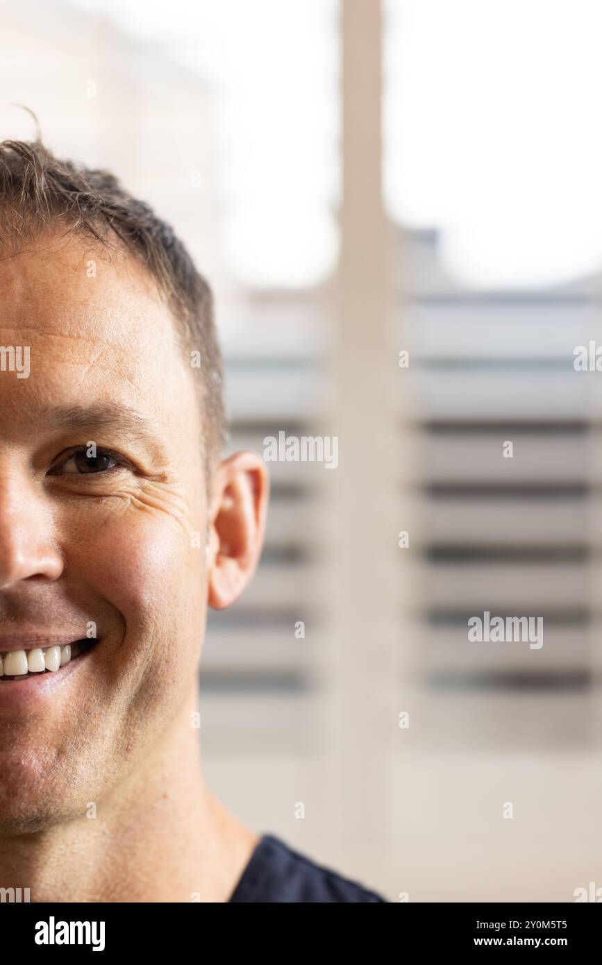 Smiling male doctor or healthcare worker in medical clinic, showcasing positive attitude and confide Stock Photo