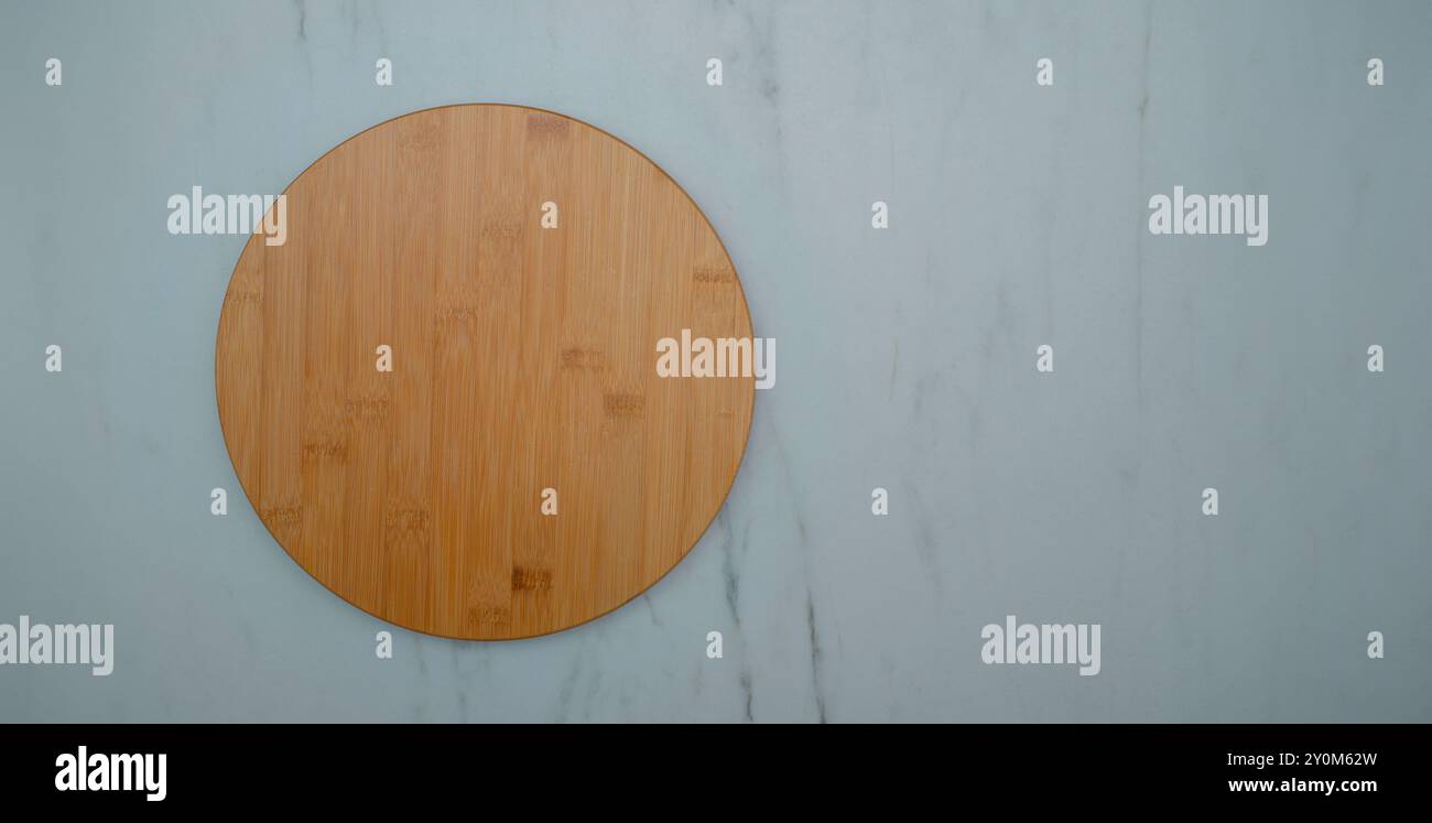 round wooden plate on white kitchen table. Stock Photo