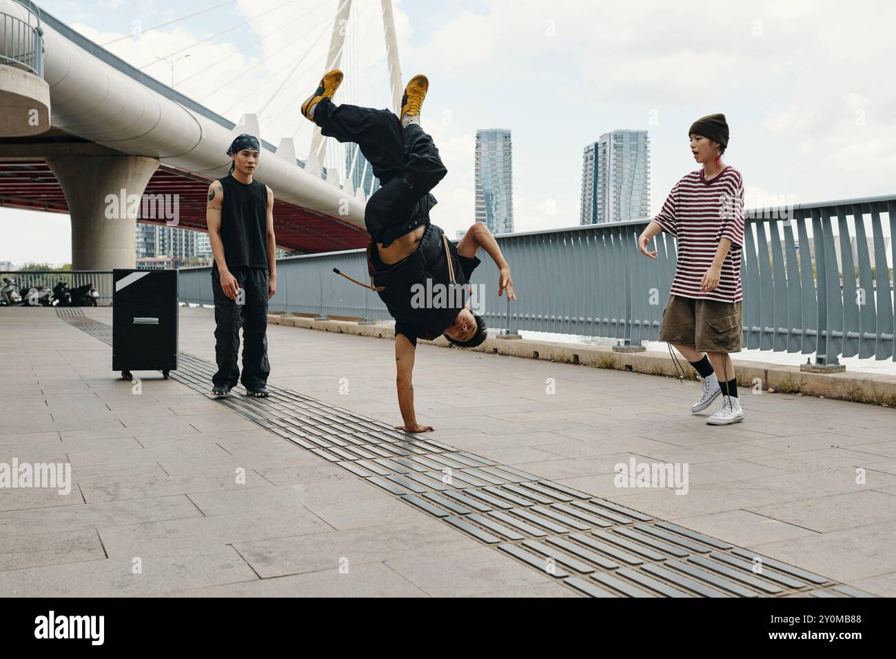 Breakdancer Performing Handstand Near Urban Bridge Stock Photo