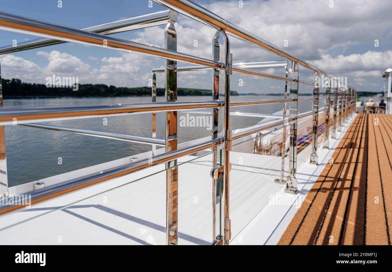 Chrome railing of a river cruise ship, with red bottom, sunny weather ...