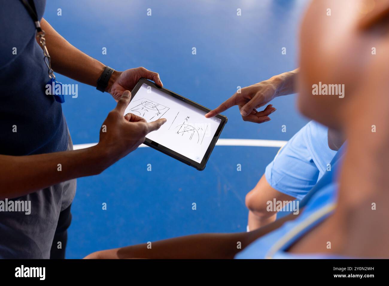 Basketball male coach using tablet to discuss game strategy with players Stock Photo