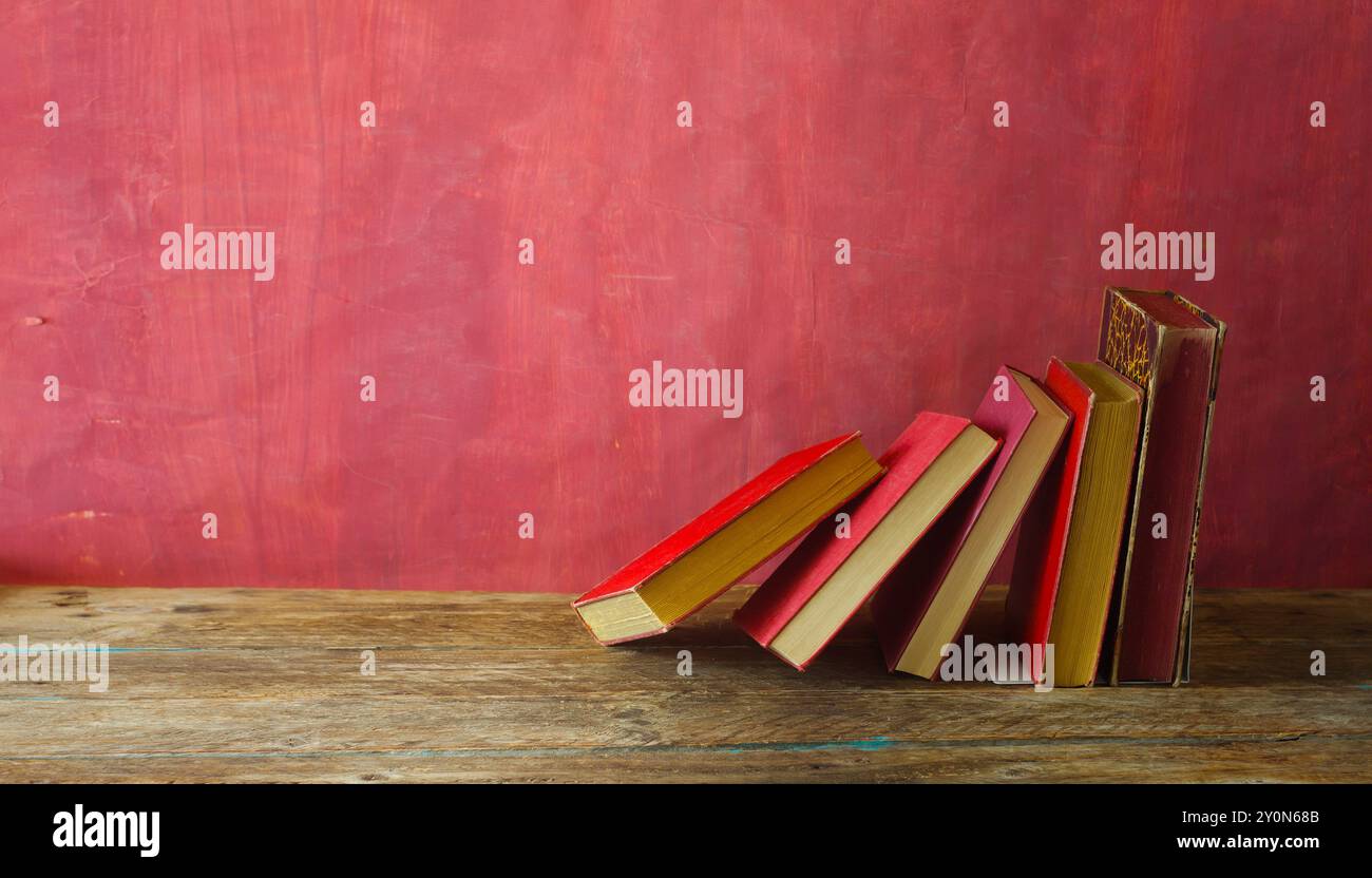 Row of red books on red grungy background, reading, learning, education or home office concept Stock Photo