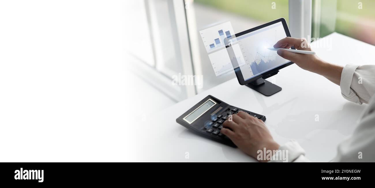 Financial Analysis Using Tablet and Calculator Stock Photo