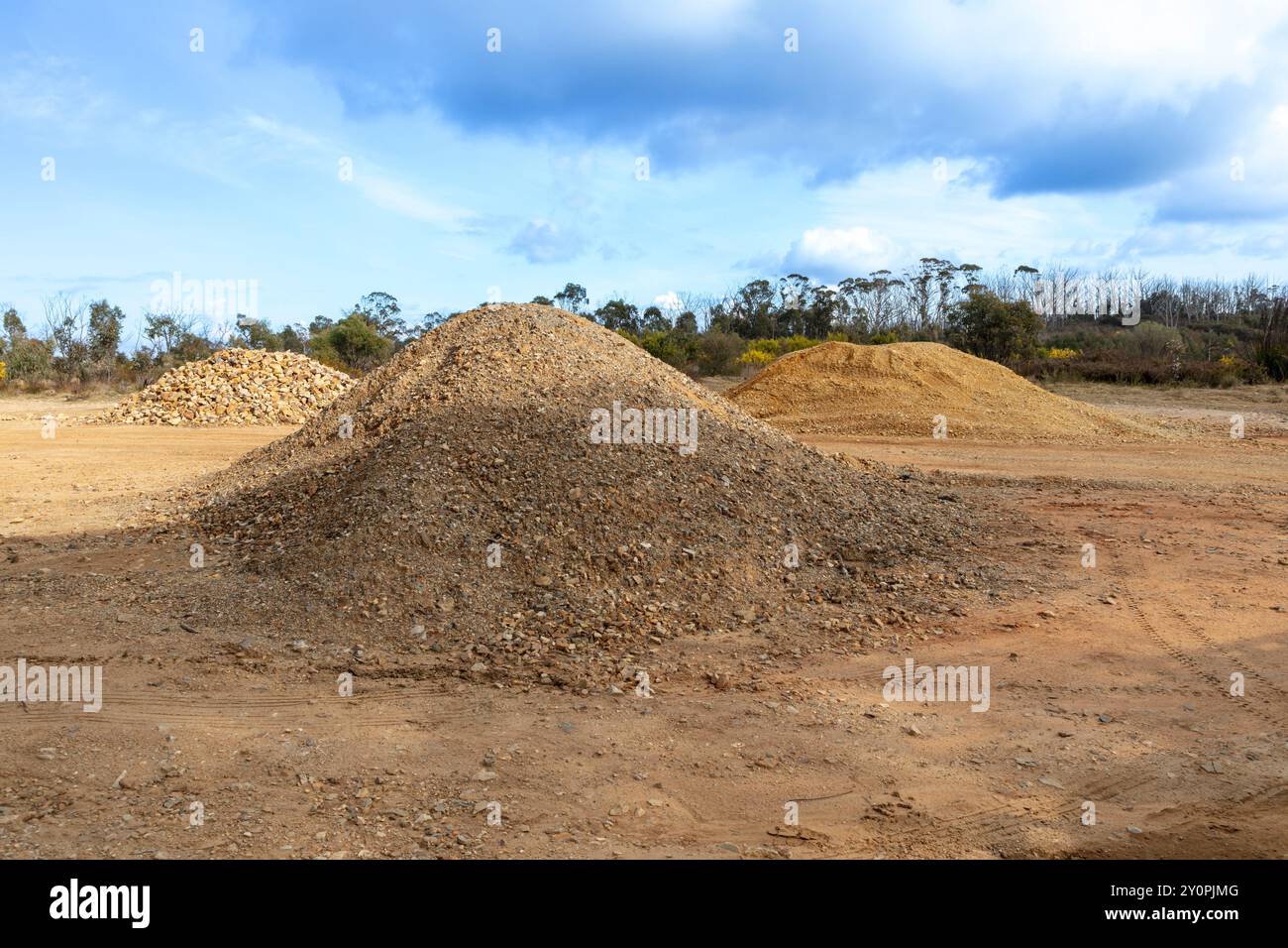 Photograph of piles of crushed rocks and gravel used for dirt road ...