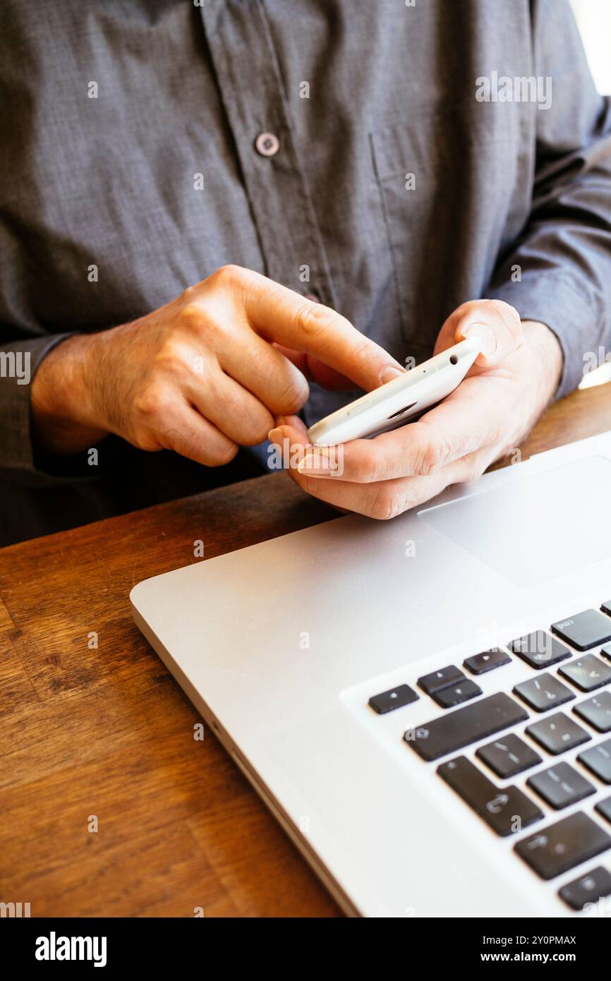 Businessman using smartphone and laptop Stock Photo