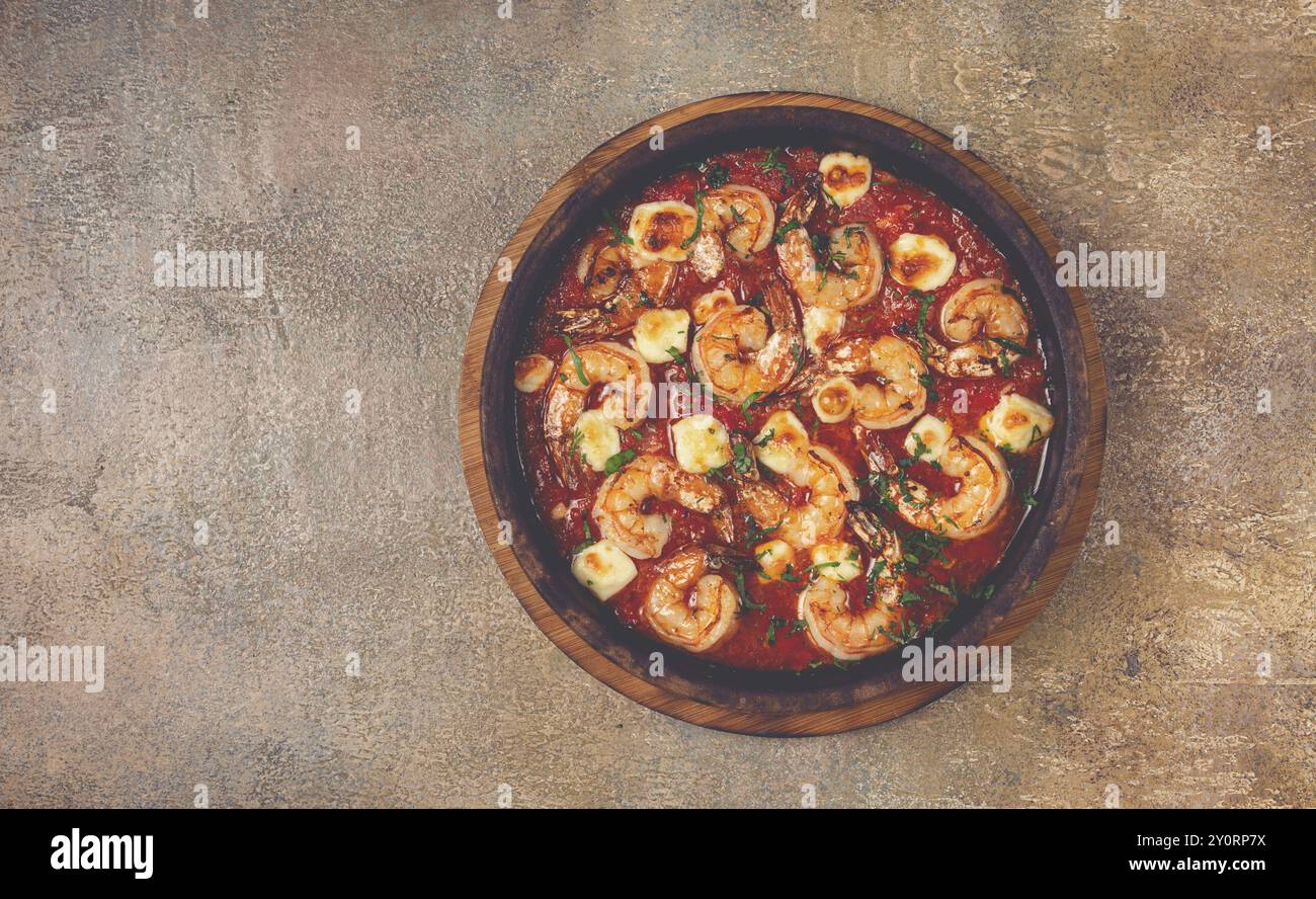 Saganaki with shrimp, in a clay pan, Greek dish, shrimp in tomato sauce ...