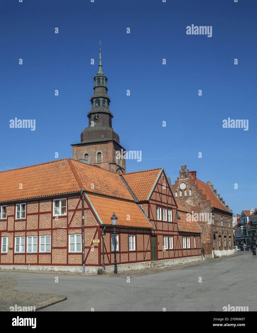 Old half-timbered building from the 18th century with St. Mary's Church from the 13th century in the background in the old center of Ystad, Skane Coun Stock Photo