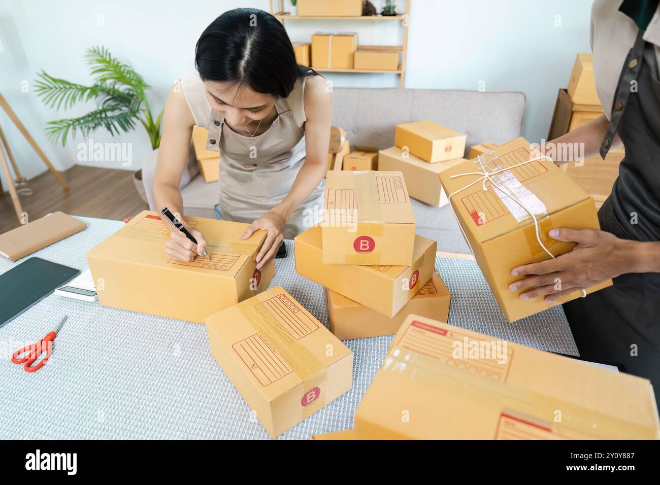 Small Business Owners Preparing Packages For Shipping In A Modern Home Office Environment 2Y0Y